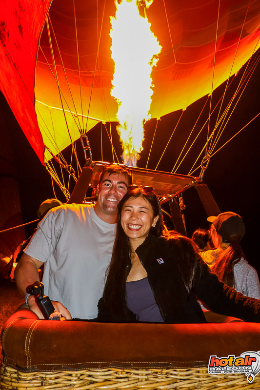 Brent and Jocelyn in the hot air balloon basket as the burner roars overhead, moments before lift-off over the Atherton Tablelands