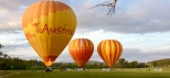 3 hot air balloon is standing on the grass about to launch