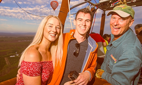 The best crew on the best balloons Hot Air Balloon pilot with happy passengers in basket smiling to camera